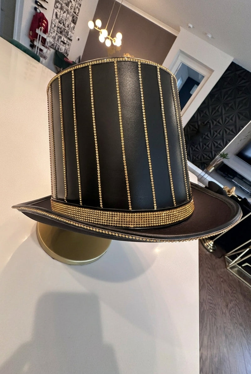 Luxury hand-embellished ringmaster top hat featuring vertical gold beadwork and a shimmering sequin band. Custom-crafted to coordinate with the signature red and gold ringmaster jacket collection.