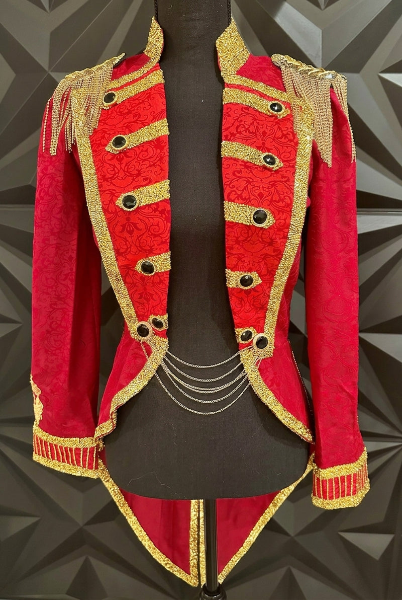 The Empress: A luxury women’s ringmaster jacket in deep crimson damask, featuring intricate hand-embellished gold bullion filigree, Swarovski crystal accents, and gold fringe epaulets. Designed by Juliana Best for high-end gala performances.